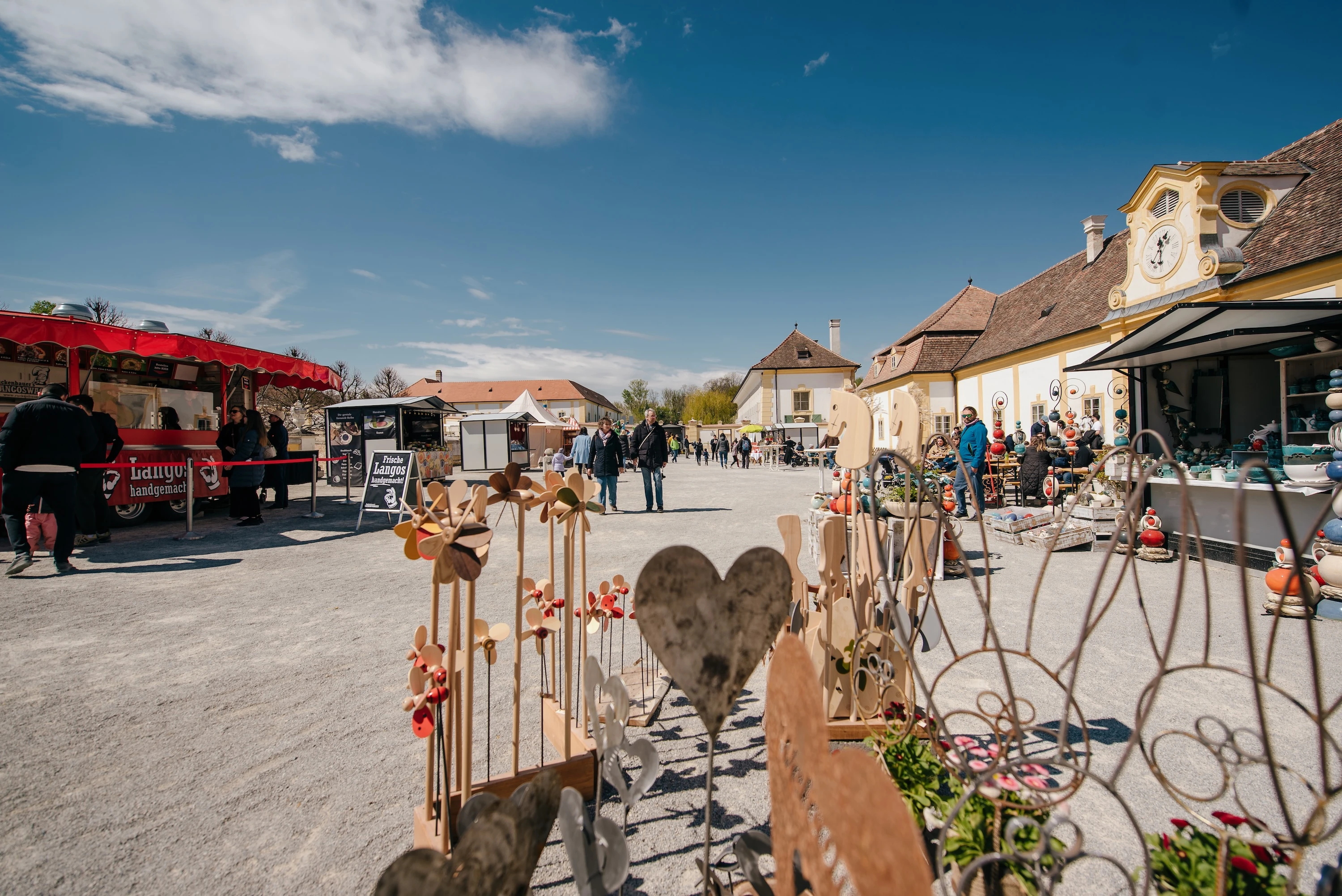 Jahrmarkt mit Kunsthandwerk und Essenstände unter blauem Himmel